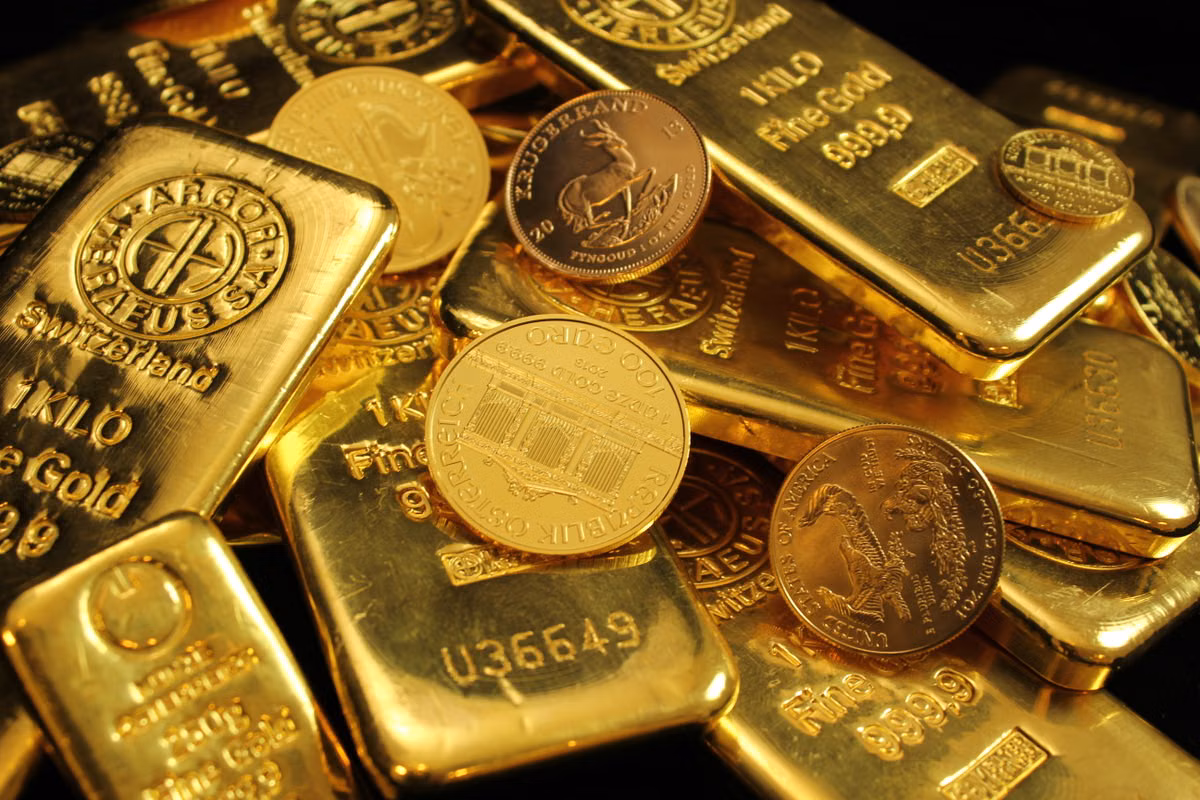 Close-up of gold bars and coins, representing the different forms of gold assets valued before a sale.