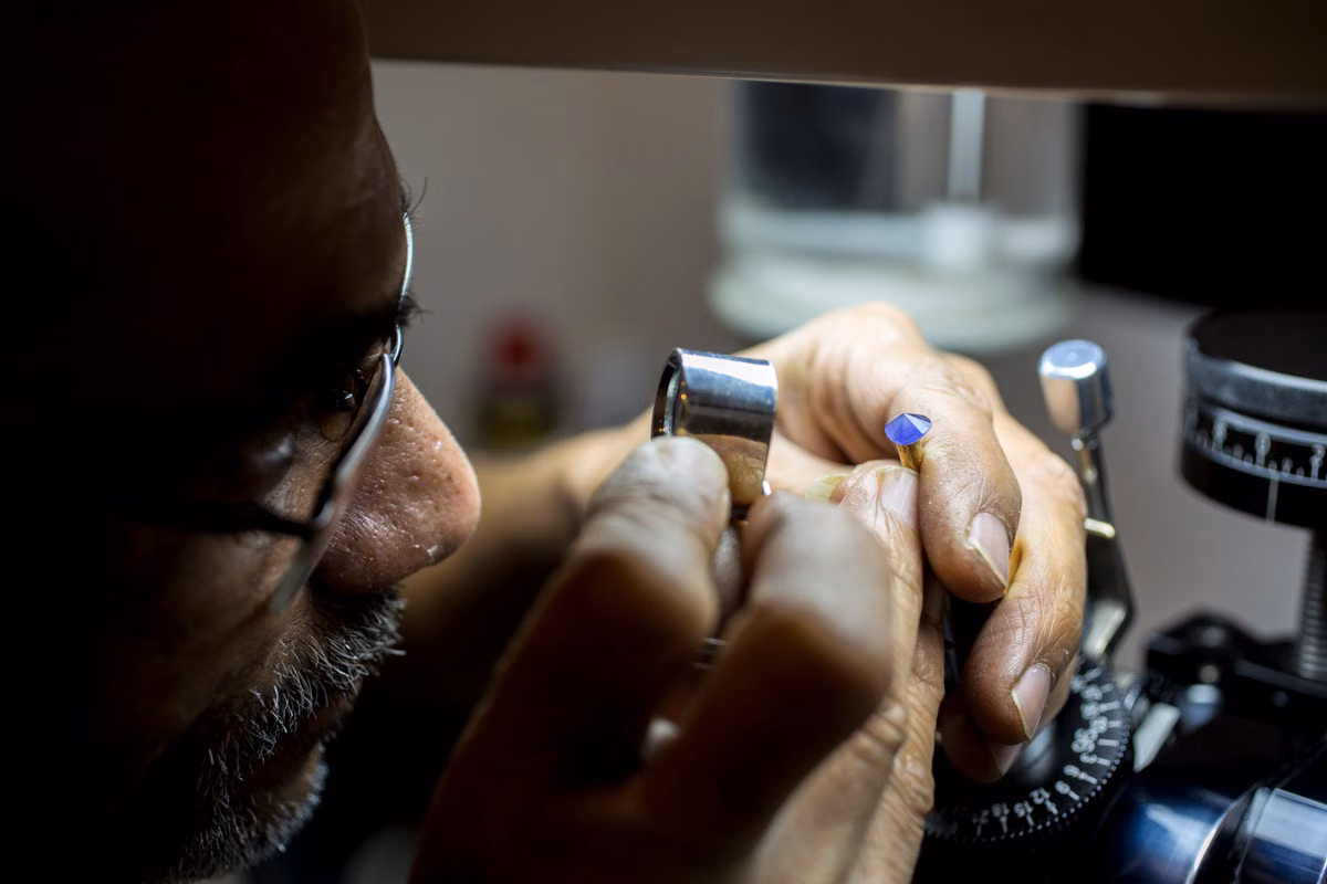 A jeweler closely inspecting a piece with precision tools, illustrating careful evaluation before a gold sale.